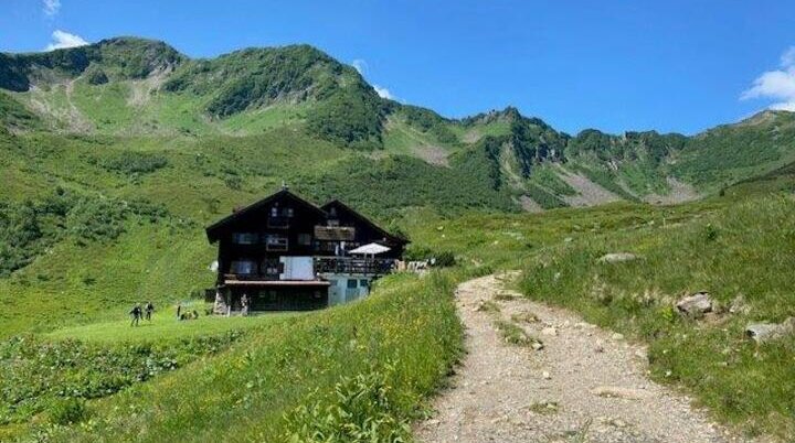 Blick auf eine Berghütte (Schwarzenkopfhütte) | © DAV Pfronten - Familiengruppe